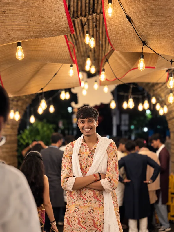 Anshul in traditional clothing beneath warm hanging lights