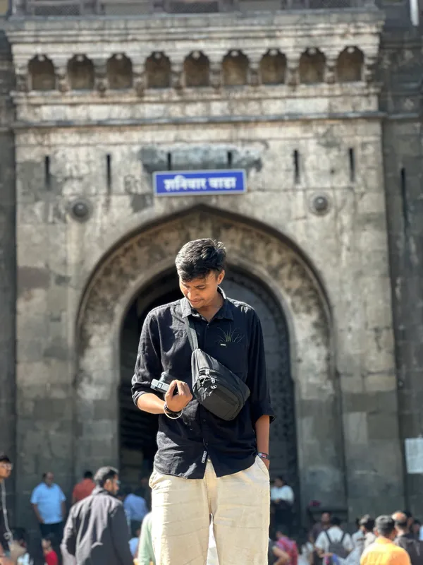 Anshul checking his camera outside an arched stone gateway